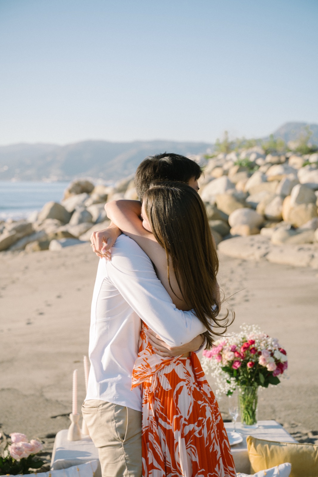 Courtney and Jonathan embrace on the beach after the proposal
